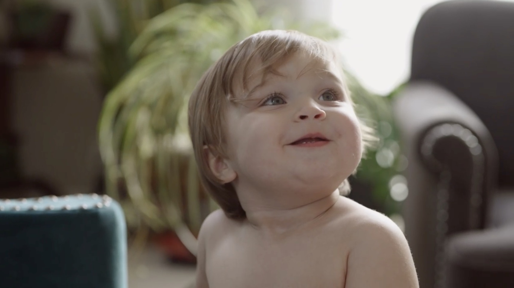 Toddler looking up in a sunlit living room