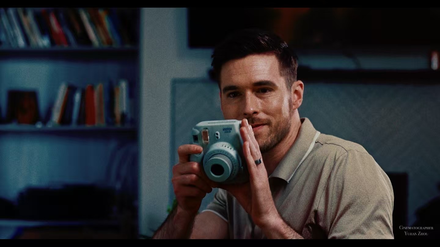 Man holding a blue instant camera