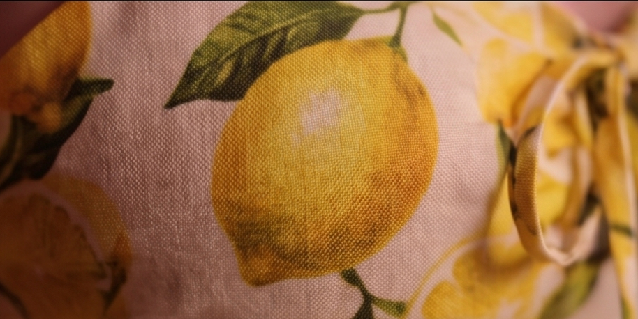 Macro of lemon-print woven fabric with a fabric tie