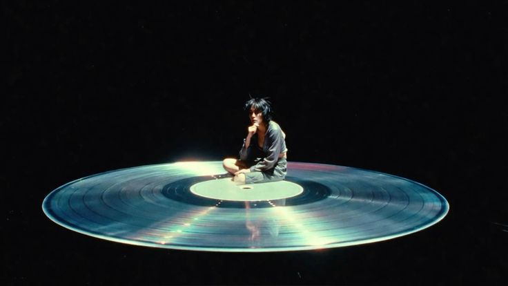 Figure sitting on vinyl record