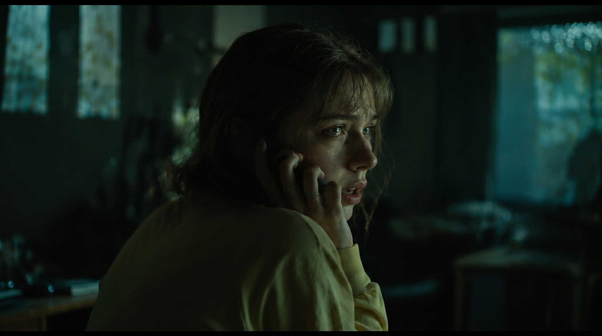 Woman on the phone in dim kitchen