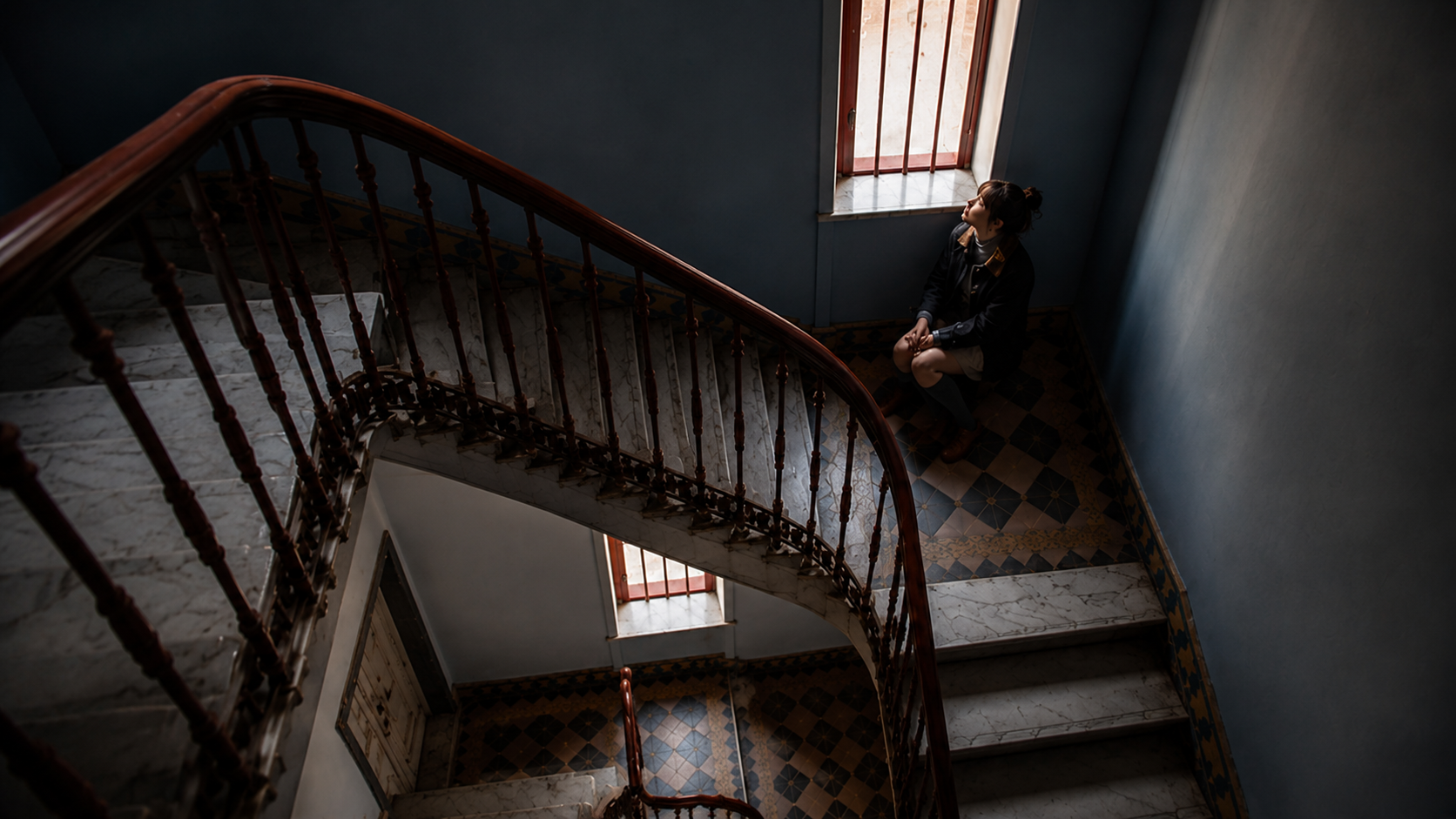 Woman in tiled stairwell light